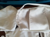 Closeup 1 A close shot of a white Olson mask showing black stitching holding the elastic down and white stitching on the area where the filter can be inserted